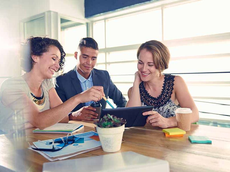 Two women and a man working at table