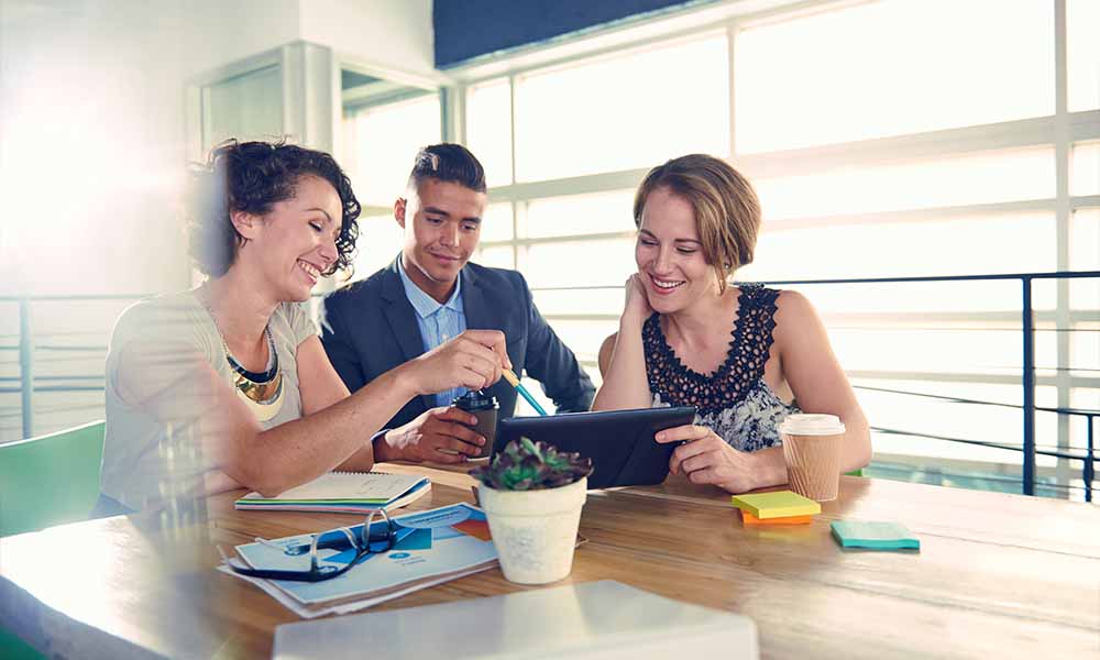 Two women and a man working at table